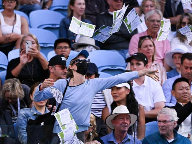 TOPSHOT – A pro-Palestinian protester throws leaflets onto the court during the men's singles match between Britain's Cameron Norrie and Germany's Alexander Zverev on day nine of the Australian Open tennis tournament in Melbourne on January 22, 2024. (Photo by WILLIAM WEST / AFP) / -- IMAGE RESTRICTED TO EDITORIAL USE – STRICTLY NO COMMERCIAL USE --