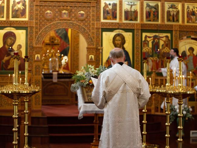 The priest reads for the congregation as images of saints watch on. Picture: Sarah Matray