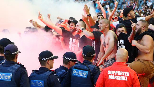 MELBOURNE, AUSTRALIA - FEBRUARY 06: Wanderers fans in the crowd let off flares as police officers look on during the round 18 A-League match between the Melbourne Victory and Western Sydney Wanderers at Etihad Stadium on February 6, 2016 in Melbourne, Australia. The FFA (Football Federation Australia) has fined the Western Sydney Wanderers $50,000 and given a suspended three-point A-League deduction after finding the club guilty of bringing the game into disrepute after 25 flares and detonators were set off during the match. (Photo by Scott Barbour/Getty Images)