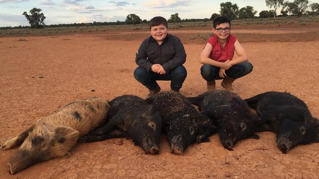 Farm kids with feral pigs that were shot on the farm. Picture: Supplied