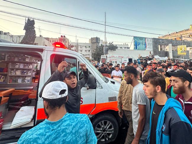 People gather around an ambulance damaged in a reported Israeli strike in front of Al-Shifa hospital in Gaza City on November 3. Picture: AFP