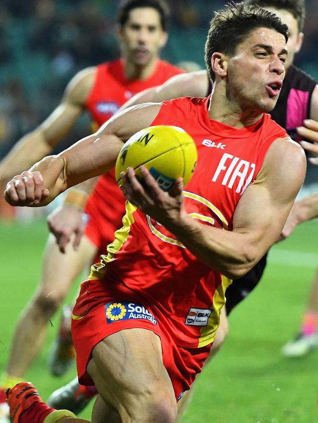 Dion Prestia gets a handball away.