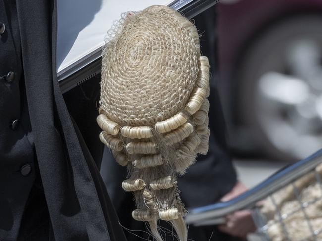 A barrister carries documents and a wig at the Supreme Court in Brisbane, Tuesday, October 29, 2019. (AAP Image/Glenn Hunt) NO ARCHIVING