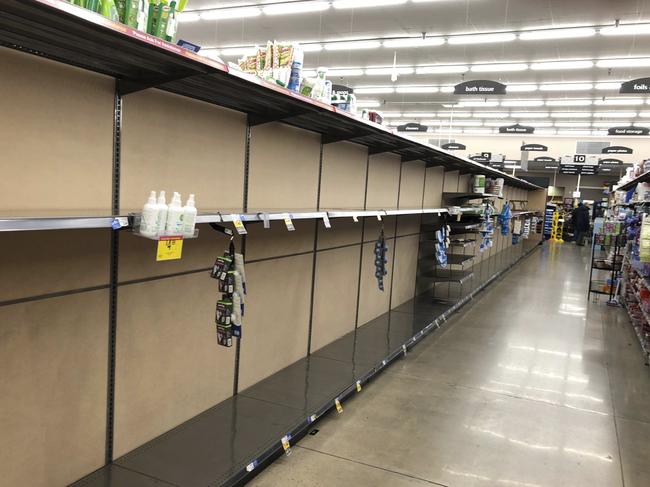 Shelves in the hand towel and toilet paper aisle stand empty five hours after a King Soopers grocery store opened its doors to shoppers Friday, March 13, 2020, in southeast Denver. Colorado Gov. Jared Polis announced measures Friday to grow the ranks of doctors, nurses and other professionals in anticipation of an increasing coronavirus caseload straining the stateâ€™s health care system. (AP Photo/David Zalubowski)