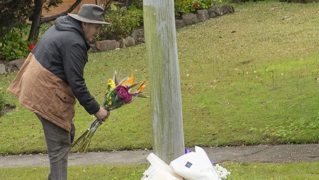 A man lays flowers at a floral tribute at the crime scene. Picture: NewsWire / Jeremy Piper