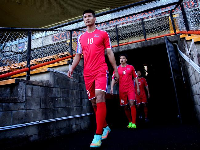 Striker Pak Kwang-ryong leads out members of the North Korea football team ahead of their opening Asian Cup match. Picture: Richard Dobson