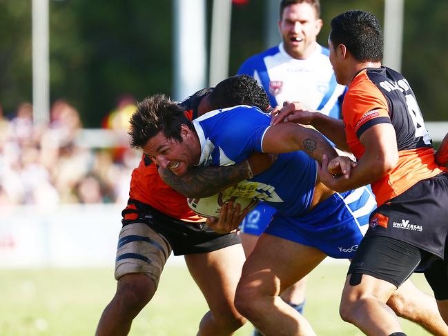 Action from the Bycroft Cup rugby league grand final match between the Tugun Seahawks (blue) and the Southport Tigers (orange). Tugun’s Bodie Clark is tackled by a bloody Marty Mitchell.