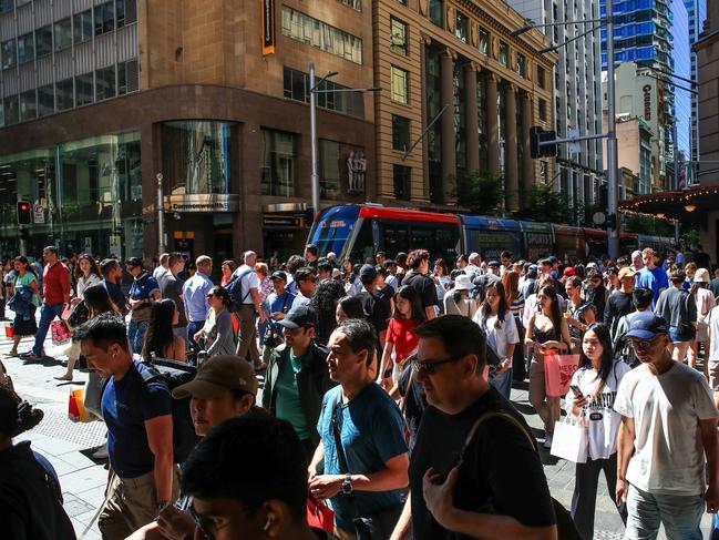 SYDNEY, AUSTRALIA - DECEMBER 24: People cross a road near Pitt Street Mall in Sydney CBD on December 24, 2024 in Sydney, Australia. The Australian economy is experiencing subdued growth, with GDP increasing by only 0.2% in the second quarter of 2024, largely due to declining consumer spending and high interest rates. Household consumption has dropped, reflecting ongoing cost-of-living pressures, as consumers prioritize necessities over discretionary spending. (Photo by Roni Bintang/Getty Images)