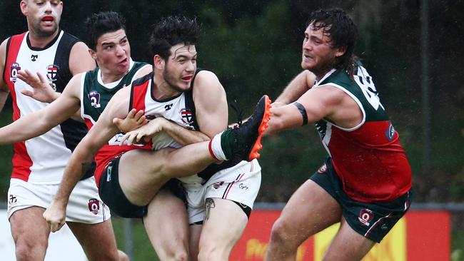 Cutters' Zach Penney squeezes a kick past Alex Galea. PICTURE: BRENDAN RADKE.