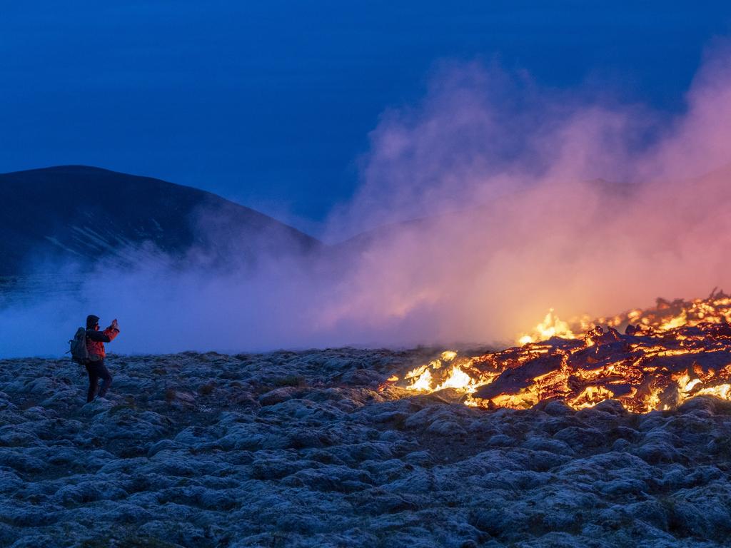 A person is pictured standing only metres away from lava as they take a photograph at the Litli-Hrútur mountain eruption site near Reykjavik. Picture: Emin Yogurtcuoglu/Anadolu Agency via Getty Images