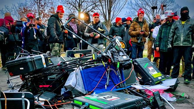 Supporters of US President Donald Trump stand next to media equipment they destroyed after rioters stormed the Capitol as Congress debated the a 2020 presidential election Electoral Vote Certification. Picture: Agnes Bun/AFP