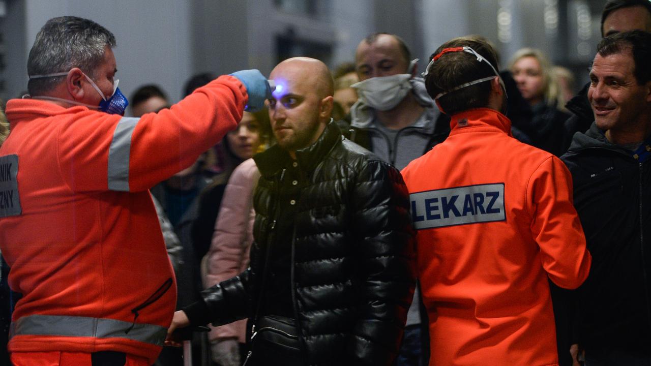 A health worker screens the temperature of a passenger arriving from Milan Bergamo to Krakow International Airport on February 26 in Krakow, Poland. Picture: Omar Marques/Getty Images