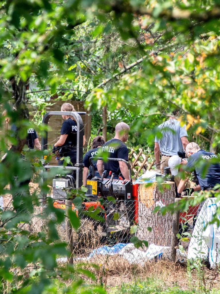 Police officers search a garden for anything in connection with Madeleine McCann. Picture: Hauke-Christian Dittrich / AFP