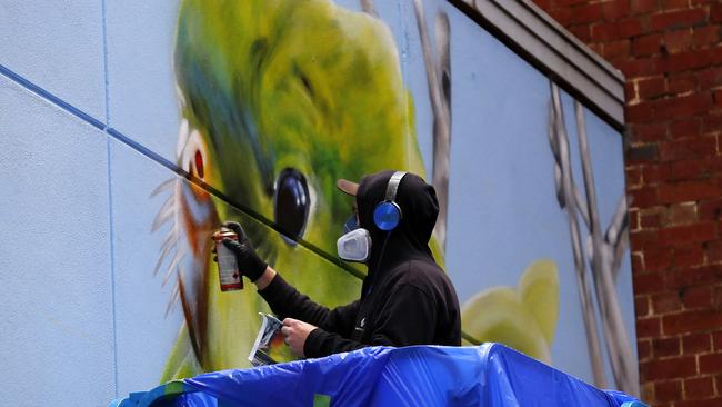 Artist Devate works on his piece in the rain. Picture: Michael Klein