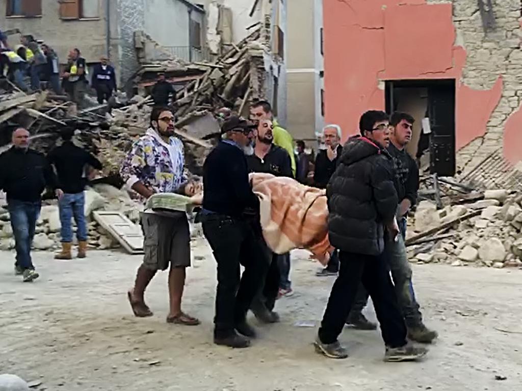 Rescuers recover a victim from a crumbled building in Amatrice, central Italy, where a 6.1 earthquake struck on August 24, 2016. Picture: AP