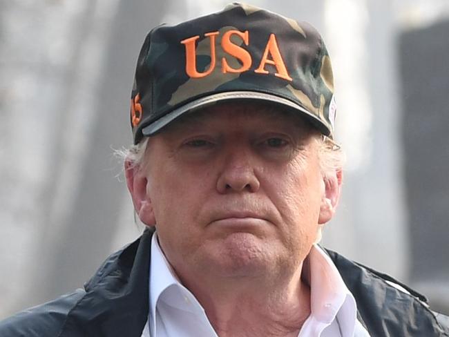 US President Donald Trump (C) looks on with Governor of California Jerry Brown (R) and Lieutenant Governor of California, Gavin Newson, as they view damage from wildfires in Paradise, California on November 17, 2018. - President Donald Trump arrived in California to meet with officials, victims and the 