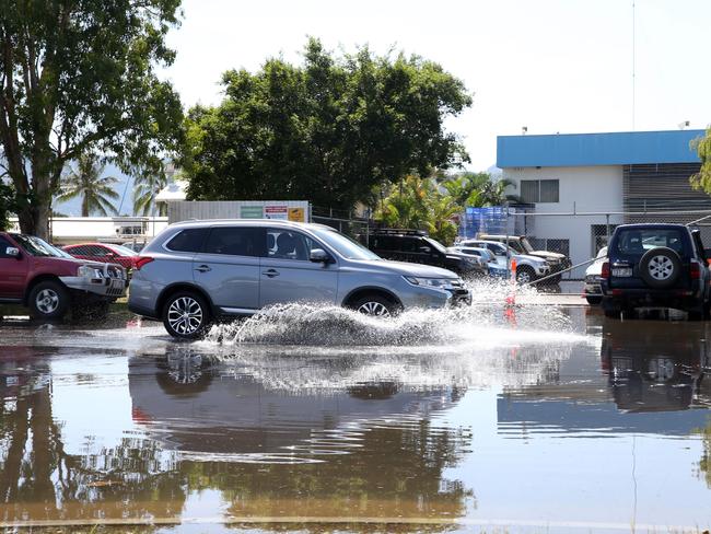 A car drives down flooded Tingira St during the king tide in Portsmith, Cairns. Picture: Anna Rogers