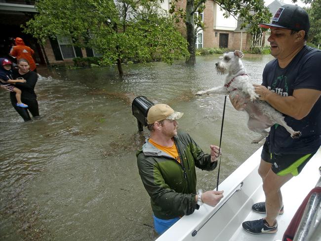FILE - In this Aug. 28, 2017 file photo, volunteers evacuate people and pets from a neighborhood inundated by floodwaters from Tropical Storm Harvey in Houston, Texas. Animal Planet is airing a special Saturday night called “Surviving Harvey: Animals After the Storm.” The program airs Saturday at 8 p.m. on the East and West coasts. Picture: AP