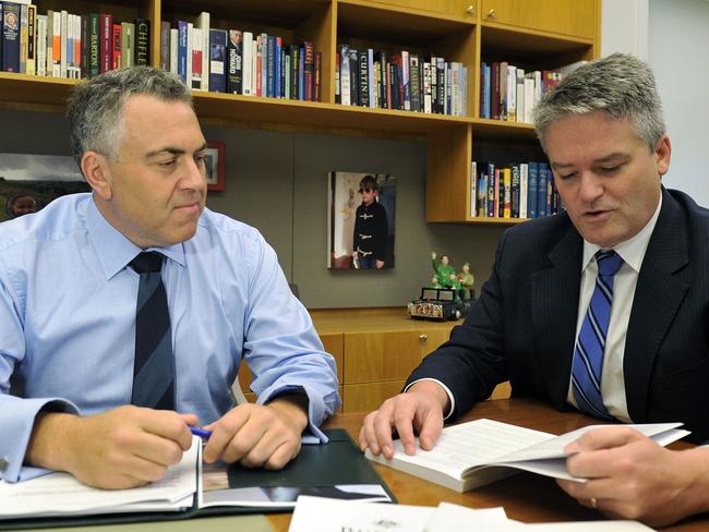 Australia's federal treasurer Joe Hockey (L) works on his budget papers with finance minister Mathias Cormann at Parliament House in Canberra on May 13, 2014. Australian Prime Tony Abbott worked to sell his government's first budget as one that will be painful but crucial for the nation's future as he braces for a voter backlash. AFP PHOTO