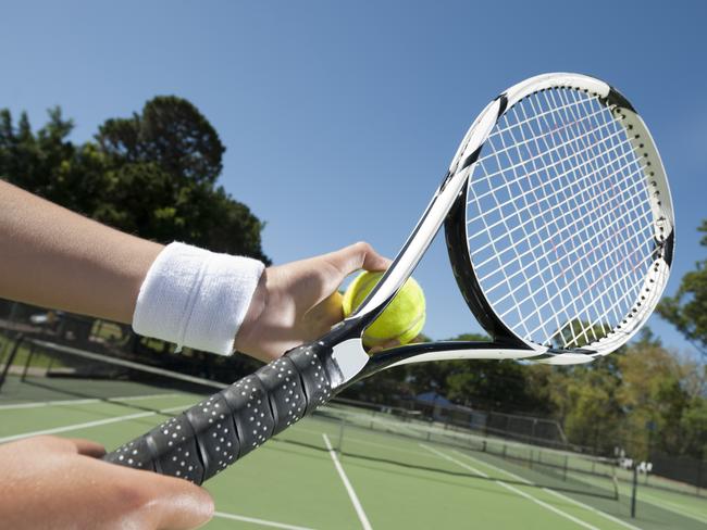 Female getting ready to serve on a tennis court