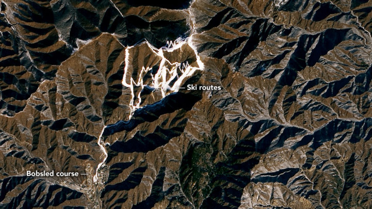 Satellite imagery shows ski routes for the Olympics made from artificial snow among brown mountains. Picture: NASA Earth Observatory