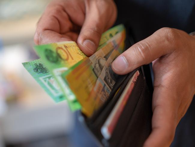 a male taking money out of a wallet, Australian cash generic spending