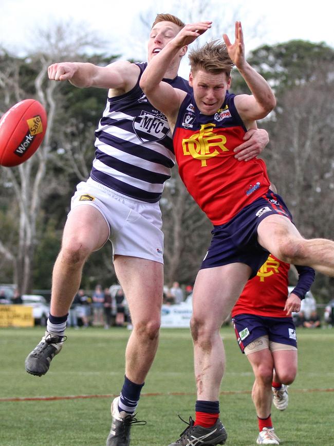 Macedon’s Matthew Dick punches the ball clear of Diggers Rest opponent Joshua Wallace. Picture: Aaron Cook