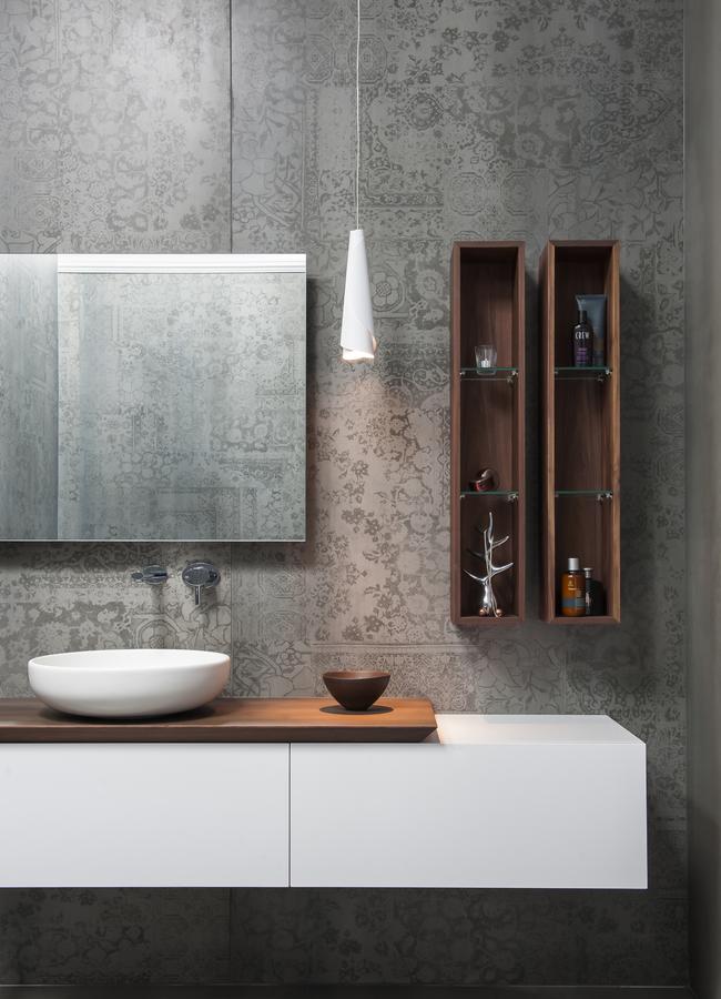 Despite its streamlined finishes, this award-winning bathroom designed by Minosa sits in a traditional home. A timber benchtop softens the sharp lines and gives it an unfitted look.