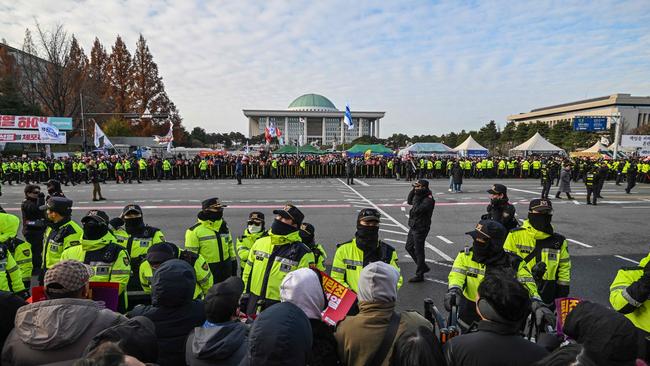 Police keep watch as people take part in a protest calling for the ouster of South Korea President Yoon Suk Yeol outside the National Assembly in Seoul. Picture: AFP