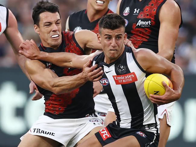 MELBOURNE. 25/04/2023. AFL. Round 6. Collingwood vs Essendon at the MCG.  Nick Daicos of the Magpies fends off Dylan Shiel of the Bombers during the 3rd qtr.  . Pic: Michael Klein