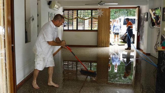 Garry Henry sweeps flood water out from a house at Caravonica, Cairns following ex-Tropical Cyclone Jasper which caused major flooding last December. Picture: Brendan Radke