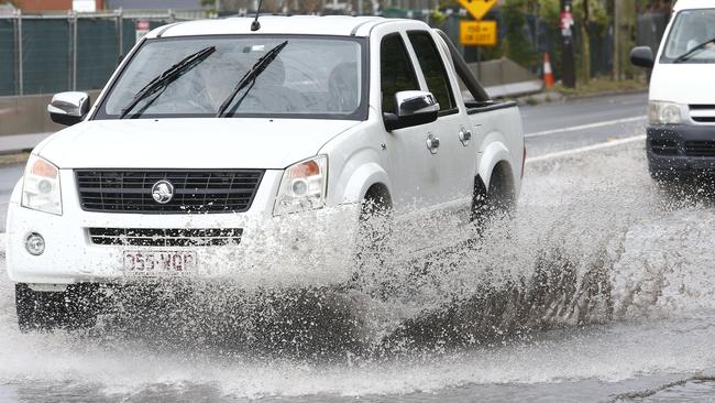 A motorist drives through a flooded road at St Peters. Picture: John Appleyard