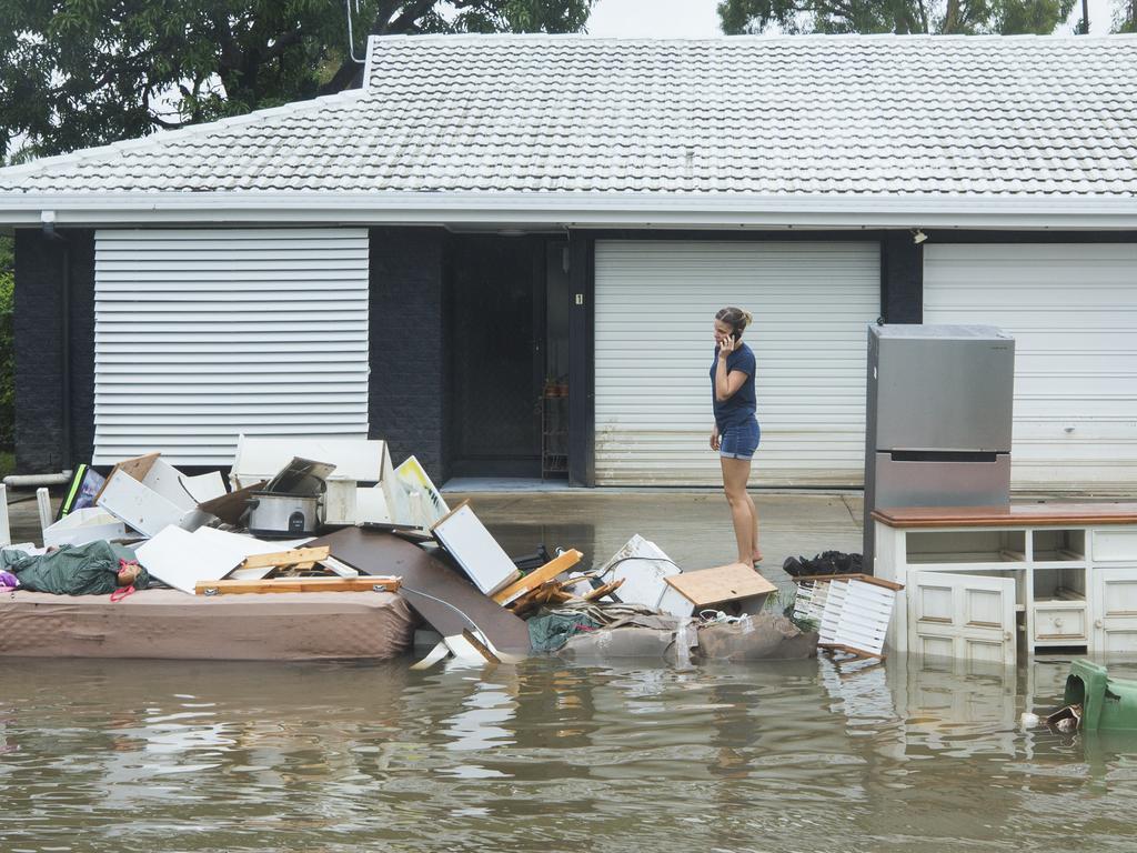 Damaged furniture and appliances lay stricken in floodwaters in the streets of Hermit Park as heavy rain continues to fall in Townsville. Picture: Lachie Millard