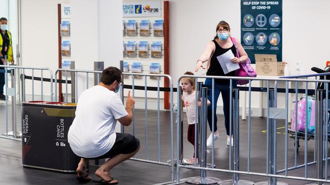 A family briefly catches up over barriers before heading into quarantine. Picture: Che Chorley