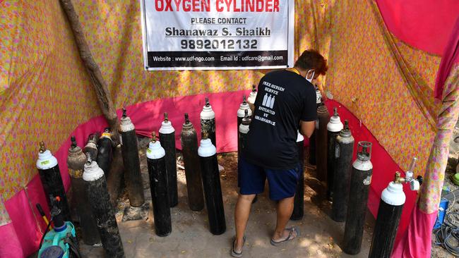 A health worker arranges oxygen cylinders at a distribution centre in Mumbai. Picture: AFP.