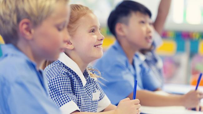 Generic photo of happy students in their classroom wearing their school uniform