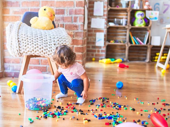 Young beautiful toddler sitting on the floor playing with small building blocks toy at kindergaten