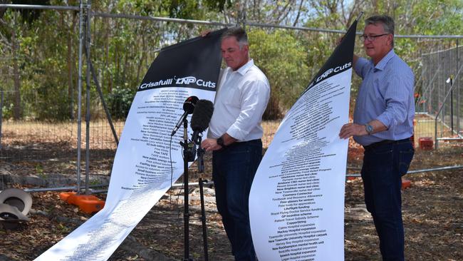 Member for Townsville Scott Stewart and Member for Mundingburra Les Walker show their lists of what they say the LNP will cut if elected during a press conference on Wednesday in Townsville.