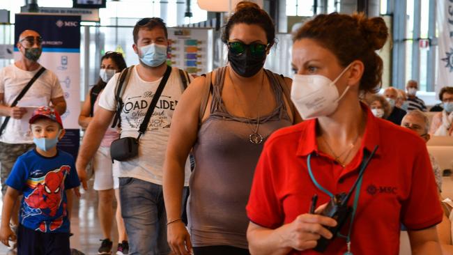 Passengers follow a hostess as they go through boarding procedures prior to depart this month aboard the MSC Orchestra cruise ship from the MSC Terminal in Italy, the first cruise ship docking at the Italian city in 17 months. Picture: Marco Sabadin/AFP