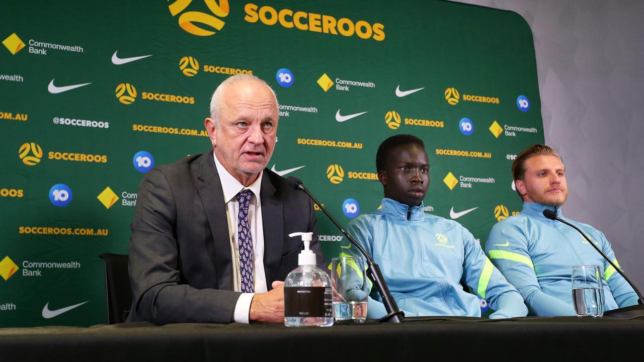 Graham Arnold is joined by players Garang Kuol and Jason Cummings. Photo by Lisa Maree Williams/Getty Images.