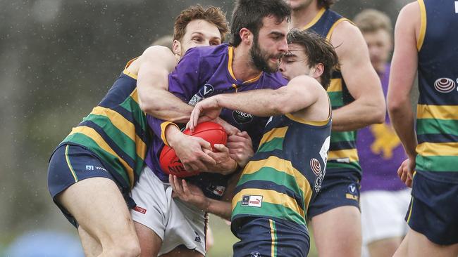 Collegians’ Christian Middleton is swamped by SKOBs pressure. Picture: Valeriu Campan