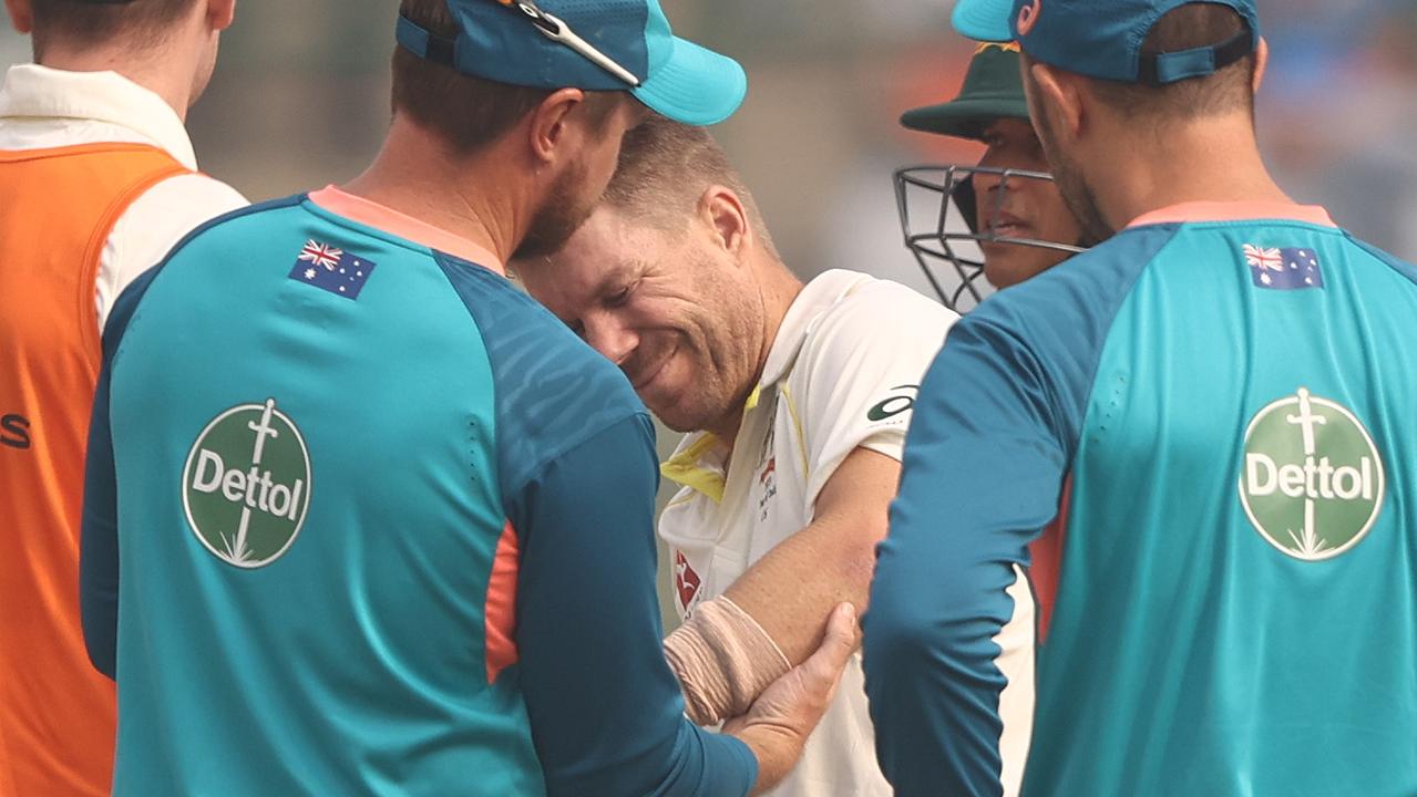 David Warner of Australia has his elbow looked at by medical staff after he was struck by a ball from Mohammed Siraj of India. Picture: Robert Cianflone