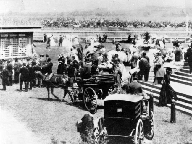 Punters arrive to the grandstand enclosure in horse drawn carriages in 1903.