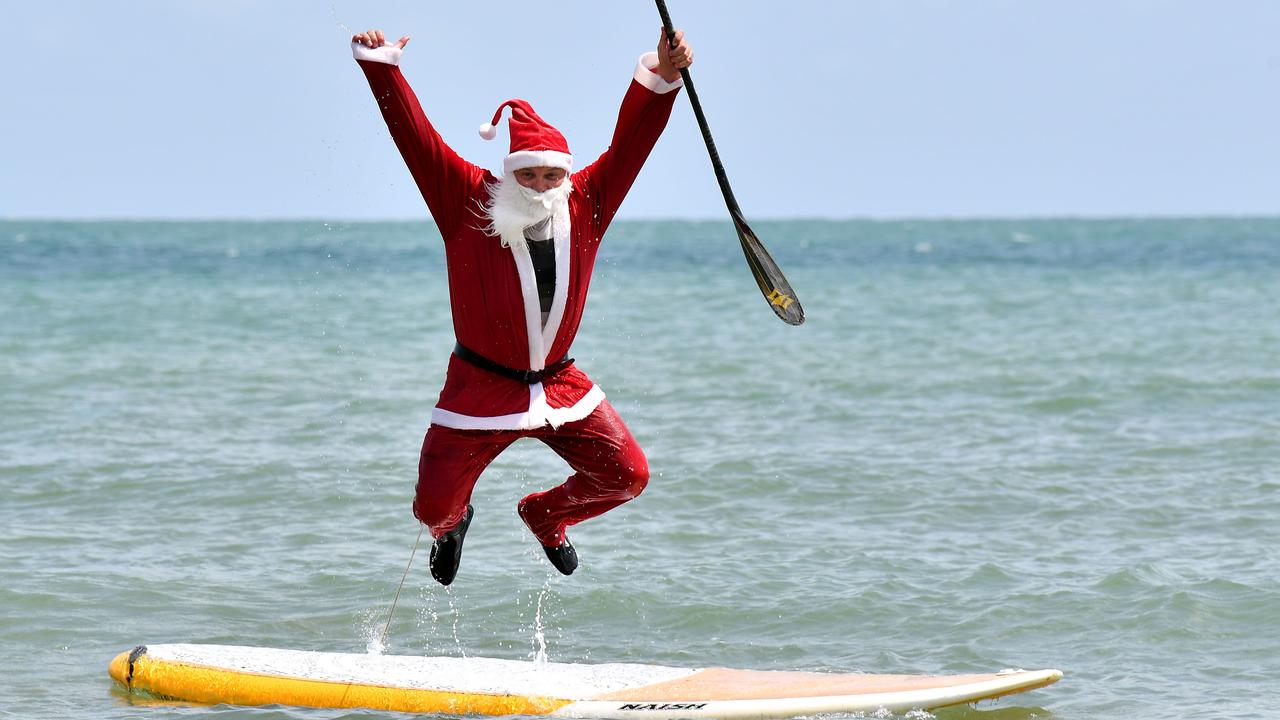 Santa (Ross Gee) has a dip at Eimeo Beach before Christmas. Picture: Tony Martin