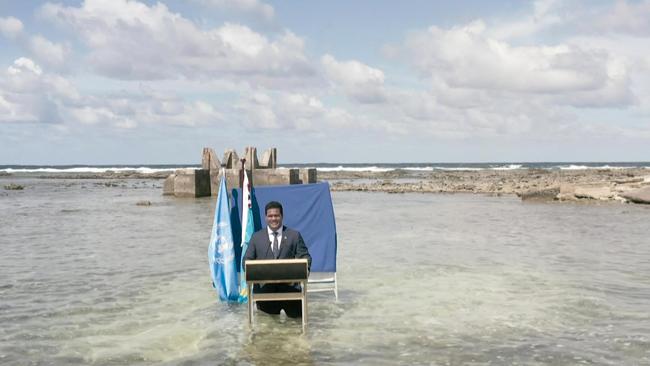 Tuvalu's Foreign Minister Simon Kofe standing thigh-deep in seawater off the coast of Tuvalu, as he addresses delegates at the ongoing COP26 UN Climate Change Conference in Glasgow.