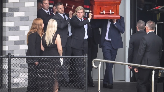 Shane Warne's son Jackson leads the pallbearers as he carries his father's coffin to a waiting hearse while his two sisters watched on. Picture: David Caird