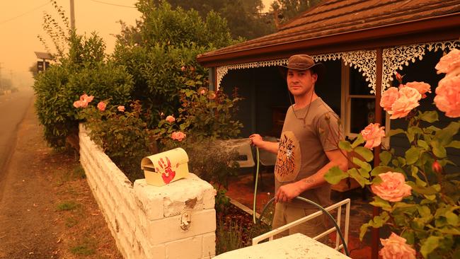 Westerway resident Daniel Horvath hosing down his property during the Gell River fire. Picture: NIKKI DAVIS-JONES