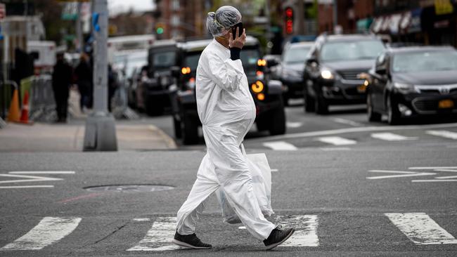 A pregnant woman wearing a hazmat suit and a mask walks in the streets in the borough of Queens. Picture: AFP