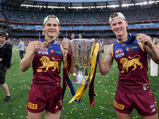 Will Ashcroft (L) and Jaspa Fletcher of the Lions pose with the 2024 AFL Premiership Trophy after winning the AFL Grand Final. (Photo by Daniel Pockett/AFL Photos/Getty Images)