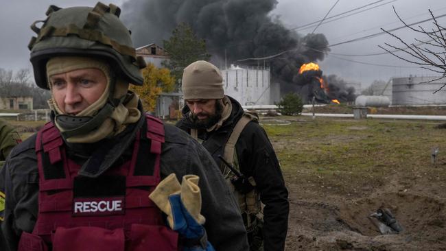 A Ukrainian rescue service member and a soldier inspect the area during an attack on Kherson. Picture: AFP